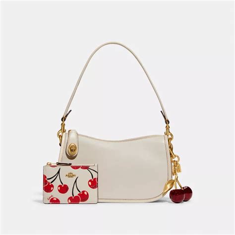 coach bag with cherry charm.